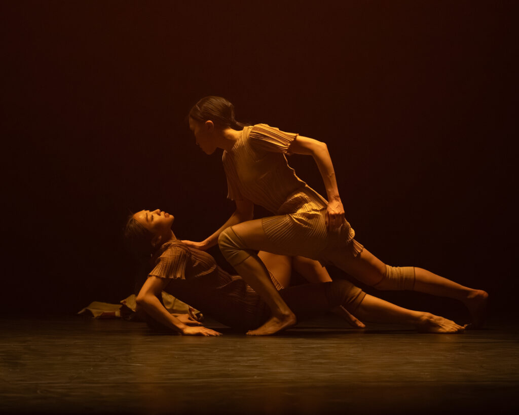 Two ENB female dancers lie together in the second section of Kameron N Saunders Proper Conduct