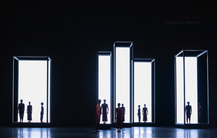 Dancers stand in silhouette against a background of backlit rectangular boxes in Yugen, part of Wayne McGregor Alchemies