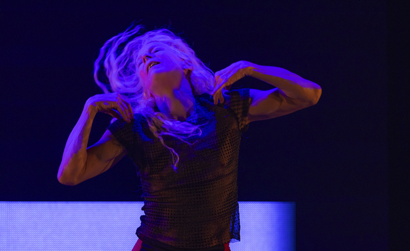 Louise Lecavalier with head bent back, long blond hair flying, arms raise to her shoulders with elbows out