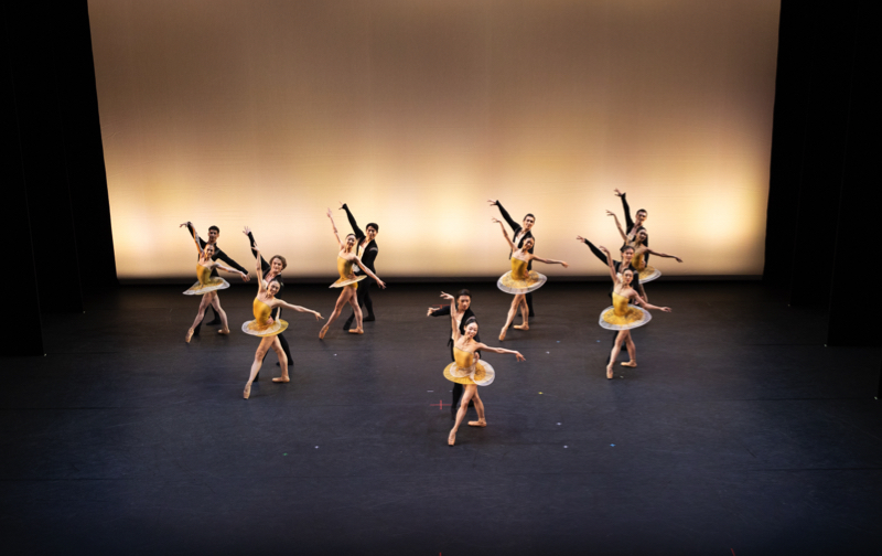 Tulsa Ballet in Classical Symphony: seven couples pose in geometrical formation. The black-clad men stand behind the women, who wear flimsy gold flat tuttus