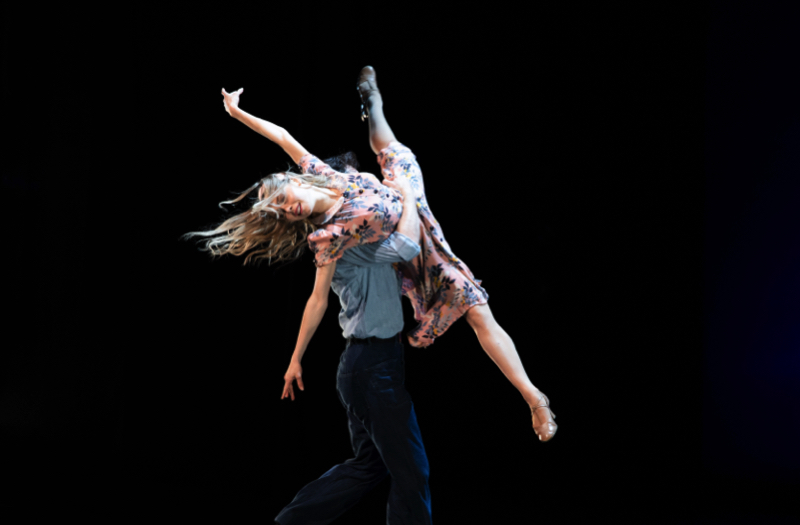 Tulsa Ballet in Remember Our Song: A man in dark trousers and ligt blue shirt lifts a woman in a 40s printed dress and loose blond hair